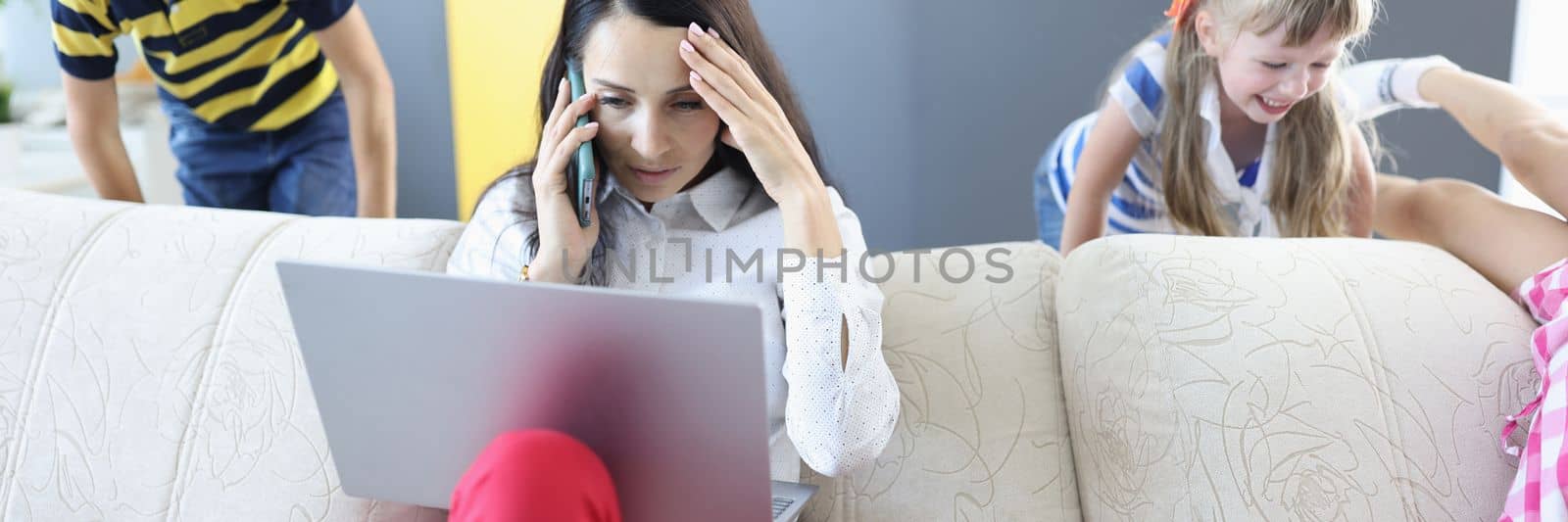 Woman working on laptop at home talking on phone and children playing. Remote work telework with kids concept