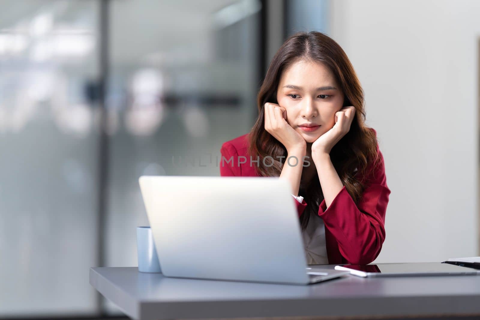 asian woman thinking hard concerned about online problem solution looking at laptop screen, worried serious asian businesswoman focused on solving difficult work computer task..