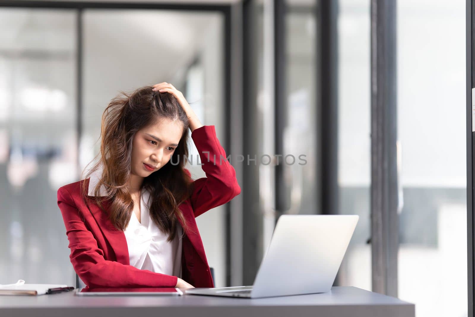 asian woman thinking hard concerned about online problem solution looking at laptop screen, worried serious asian businesswoman focused on solving difficult work computer task..