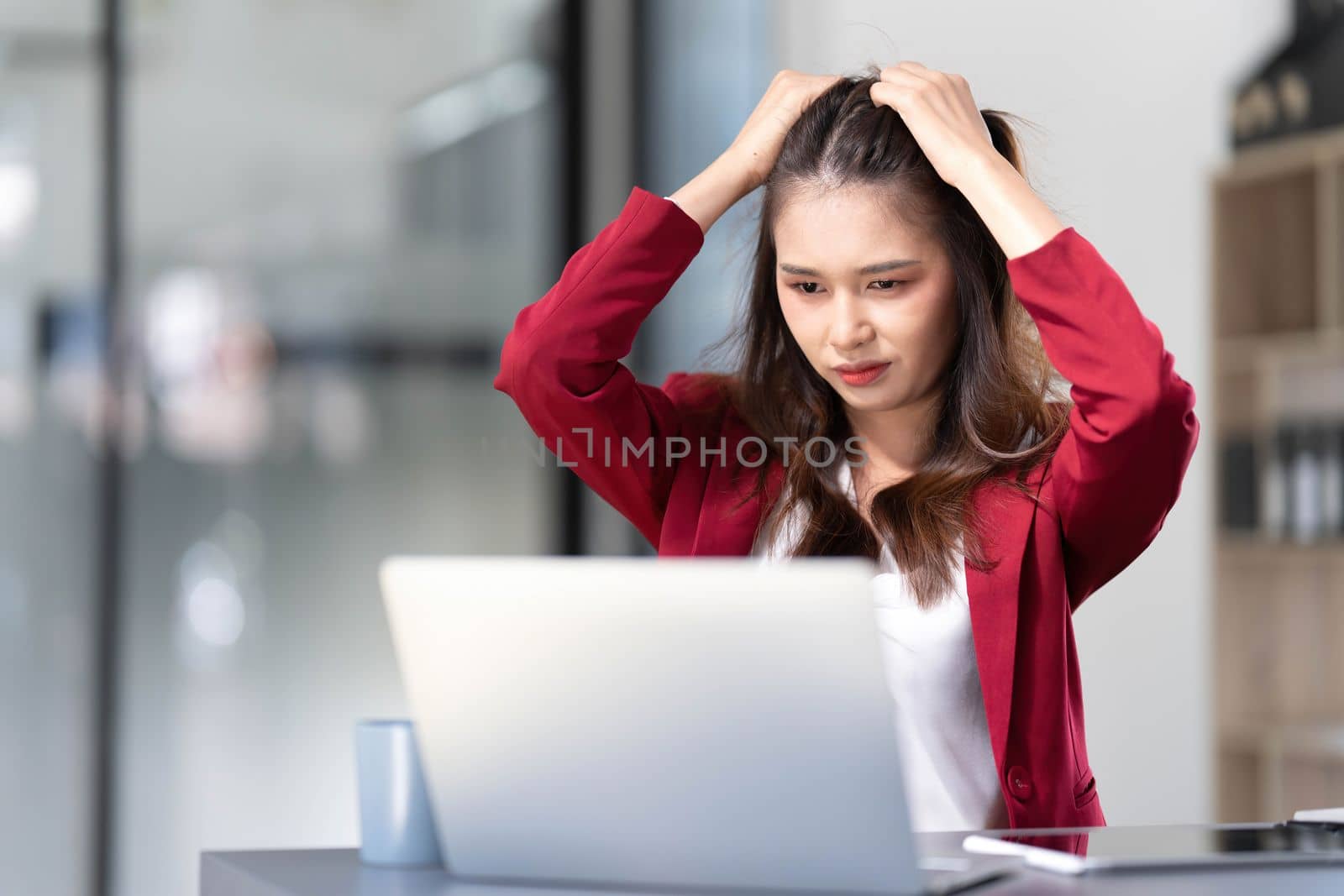 asian woman thinking hard concerned about online problem solution looking at laptop screen, worried serious asian businesswoman focused on solving difficult work computer task by wichayada