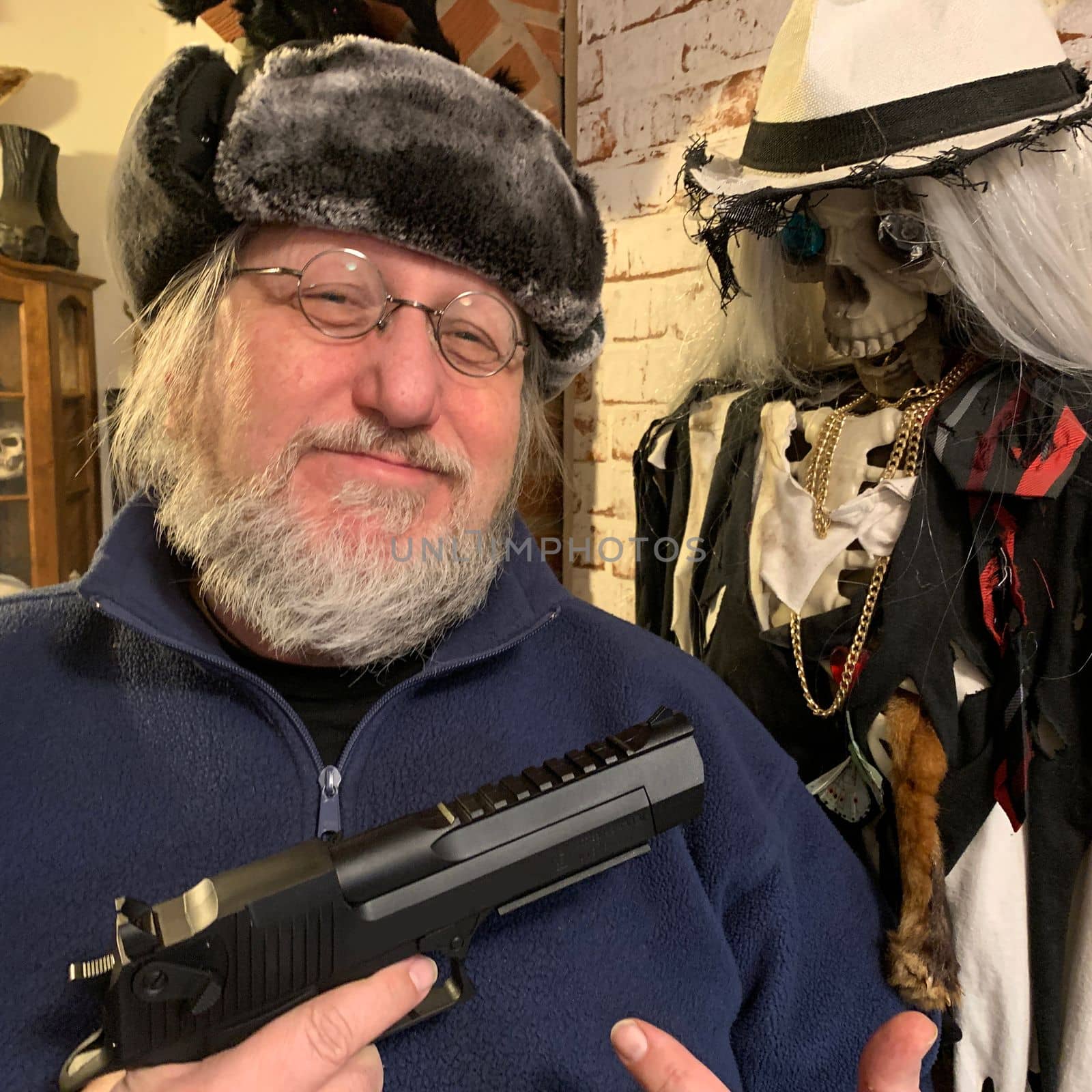 A comedian in a fur hat proudly presenting a gun beside a skeleton