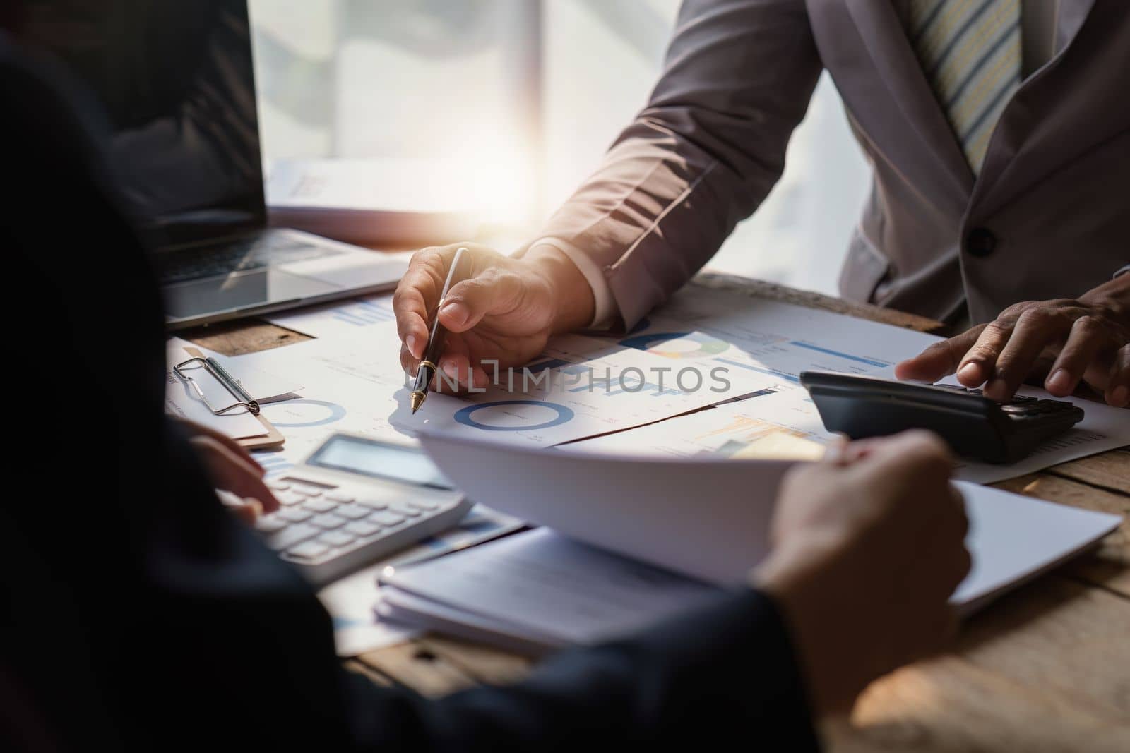 Close up of Diverse colleagues gather brainstorm discuss financial statistics at office meeting. finance, teamwork concept by itchaznong