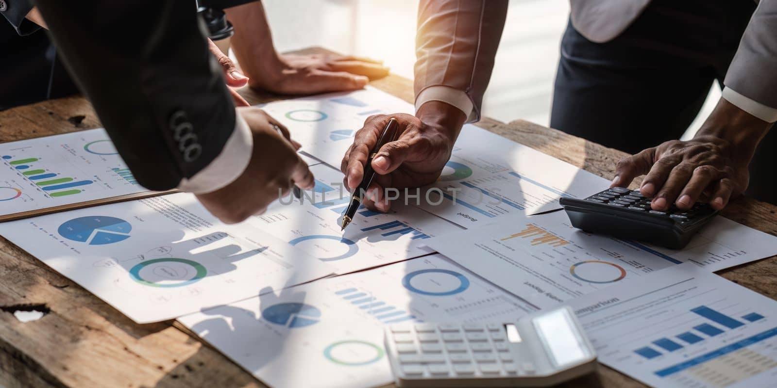 Close up of Diverse colleagues gather brainstorm discuss financial statistics at office meeting. finance, teamwork concept.