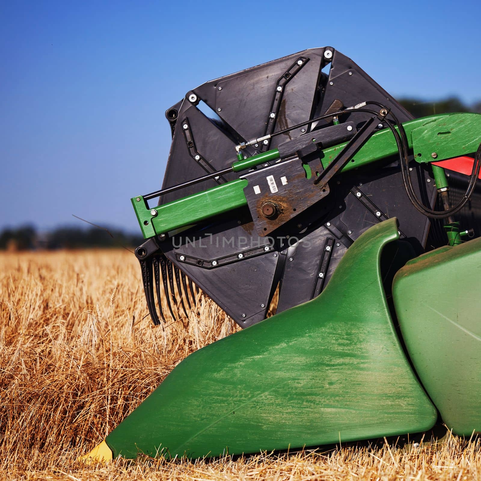 Agricultural combine John Deere harvester in the field during harvest ripe wheat. Combine working on a wheat field. Combine Harvester harvesting crops. 07.07.22, Rostov region, Russia by EvgeniyQW