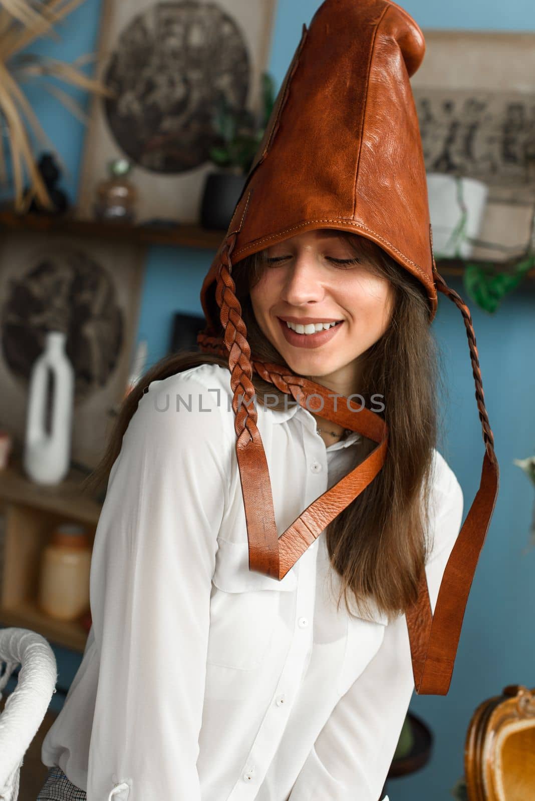 close-up photo of orange leather bag on a womans had. indoor photo. beautiful girl in a white blouse having fun with a handbag