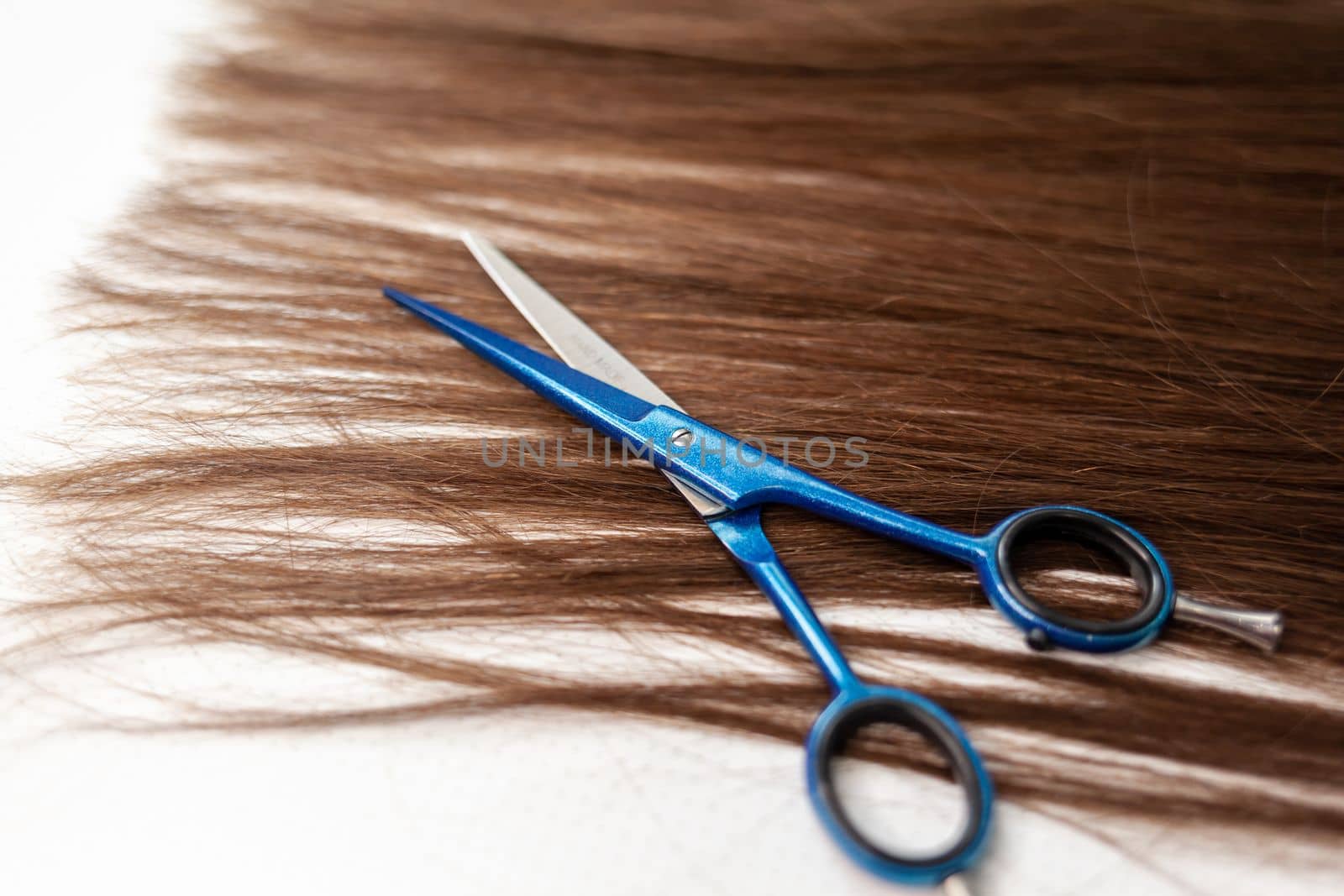 Scissors lie on the hair ribbon for extension at home. Hair extensions to thicken your own. Individual strands of hair close-up