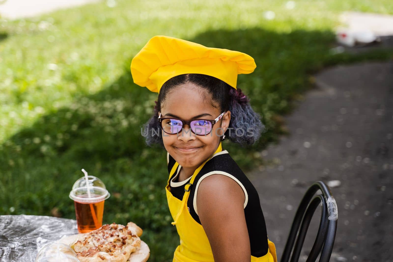 Black african cook child girl sin chefs hat and yellow apron uniform smiling outdoor. by Rabizo