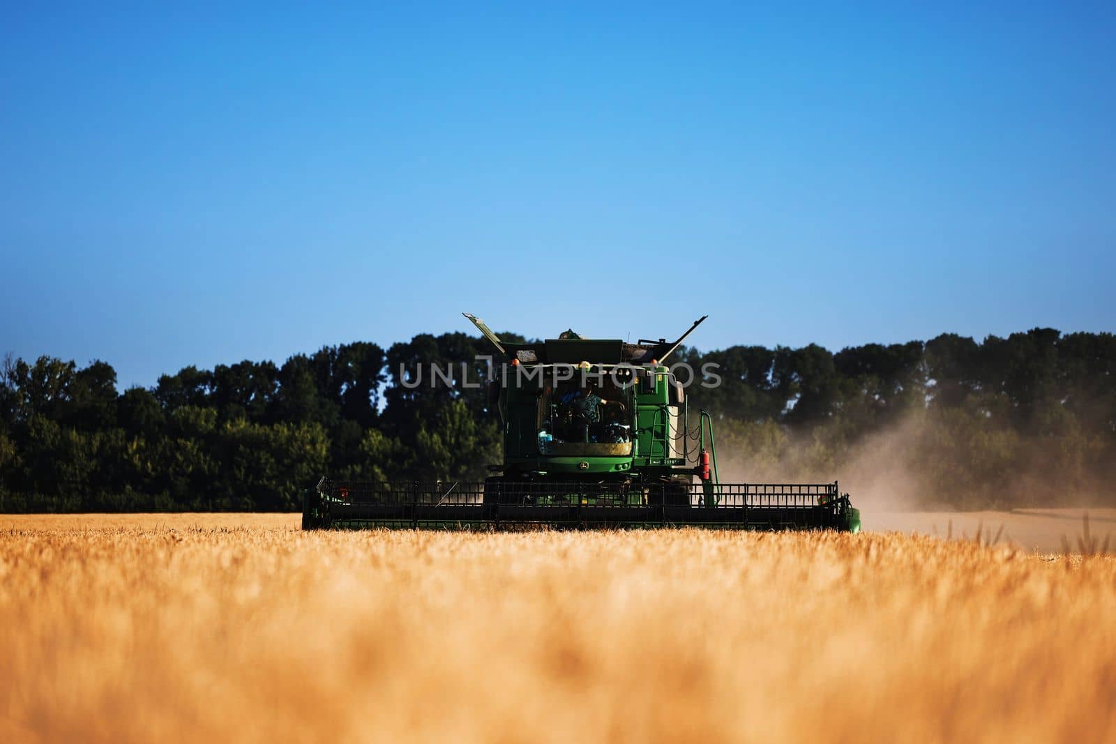 John Deere harvester works in the field. Combine Harvesting Wheat. Field field of cereals during harvesting. Modern equipment works. 07.07.22, Rostov region, Russia.