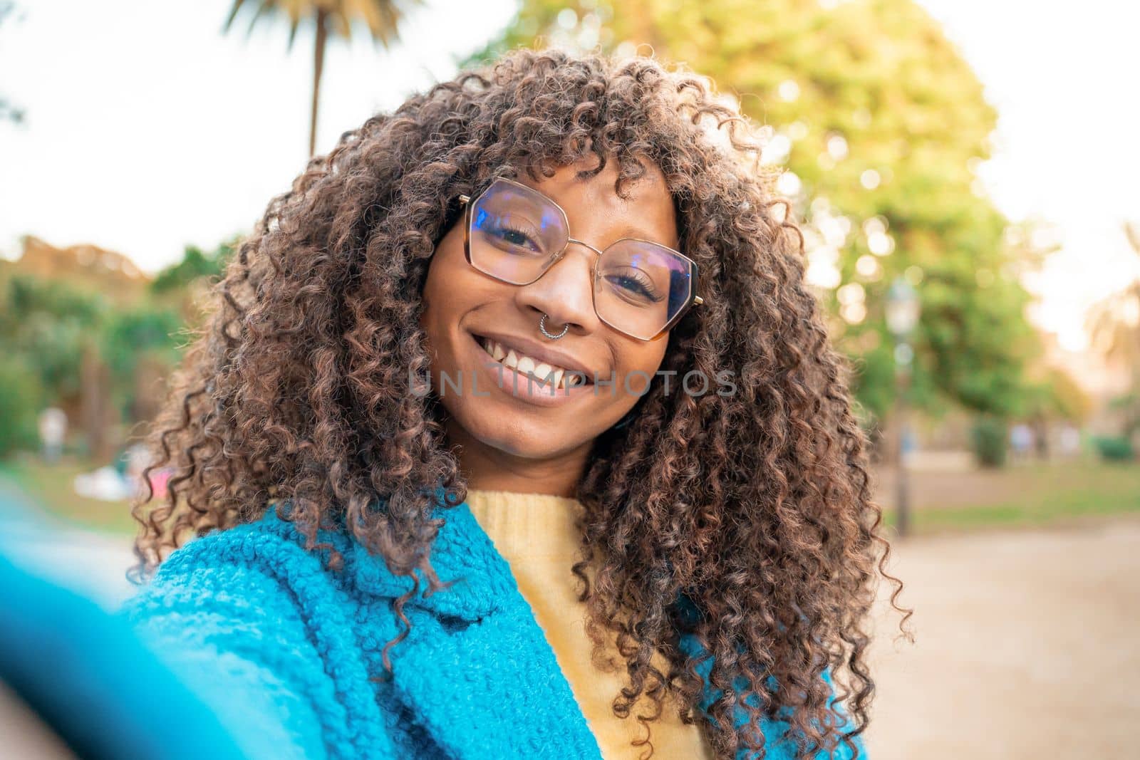 Beautiful African American woman smiling taking selfie. Positive cheerful trendy girl posing by PaulCarr