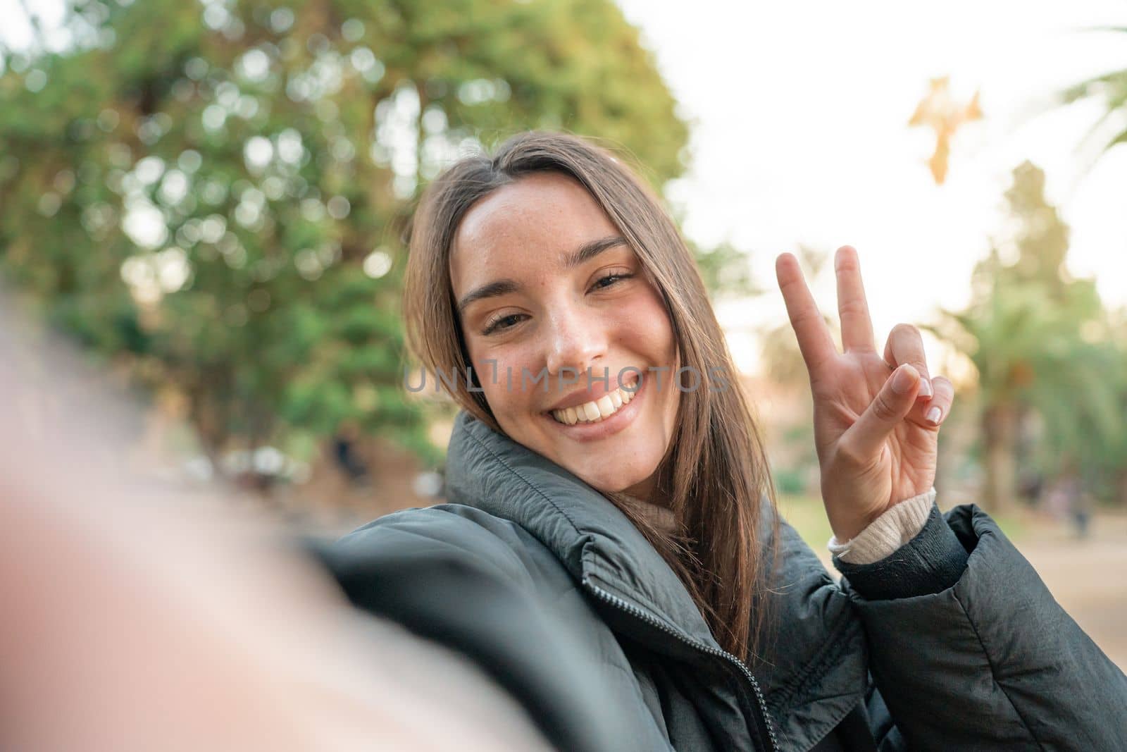 Young beautiful woman smiling taking selfie photo at university campus. Trendy girl in casual attire by PaulCarr