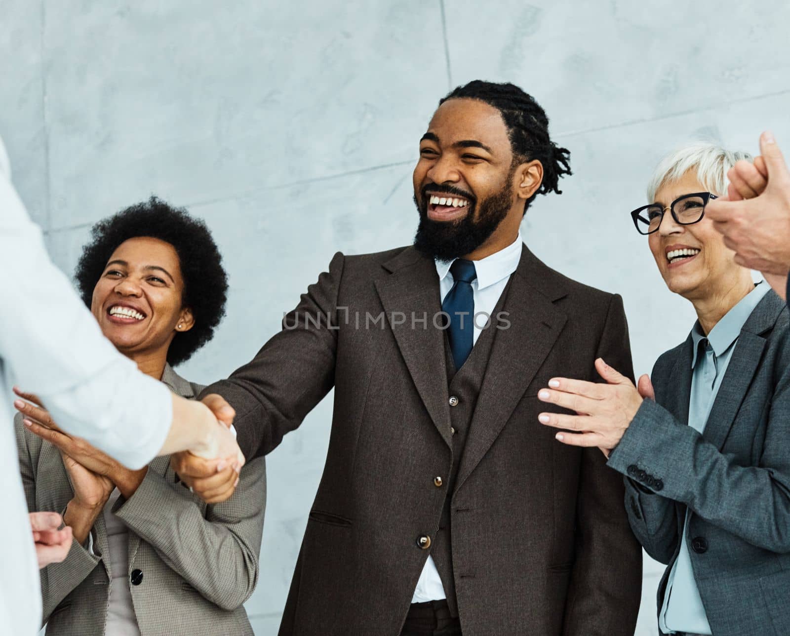 Group of young and senior business people having a meeting and signing a contract agreement and shaking hands handshake in the office. Teamwork and success concept