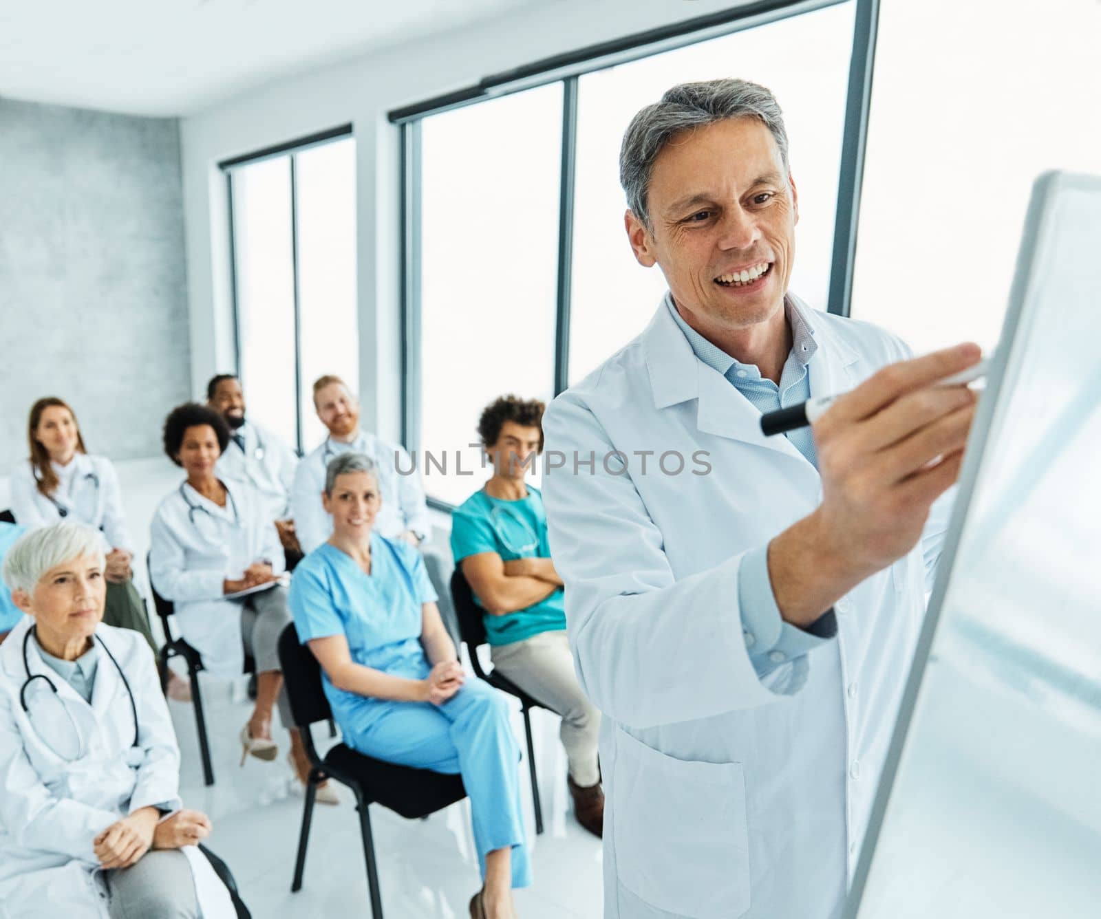 Portrait of a young doctor teaching on a seminar in a board room or during an educational class at convention center