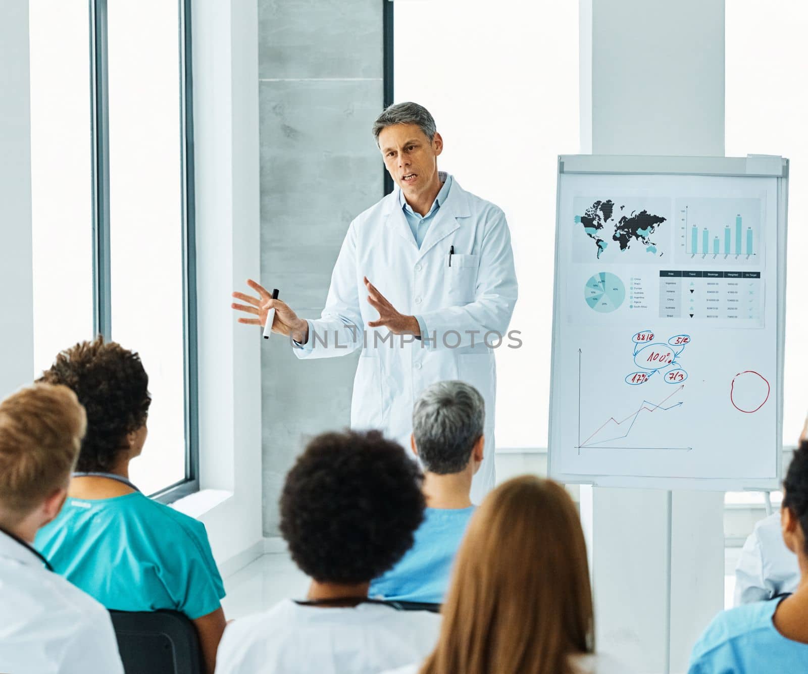 Portrait of a young doctor teaching on a seminar in a board room or during an educational class at convention center