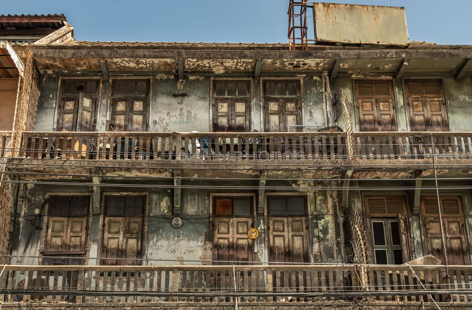 External of old building with wooden windows and wooden door on balconies was left to deteriorate over time, Chinese Architecture style, Old house, No focus, specifically.