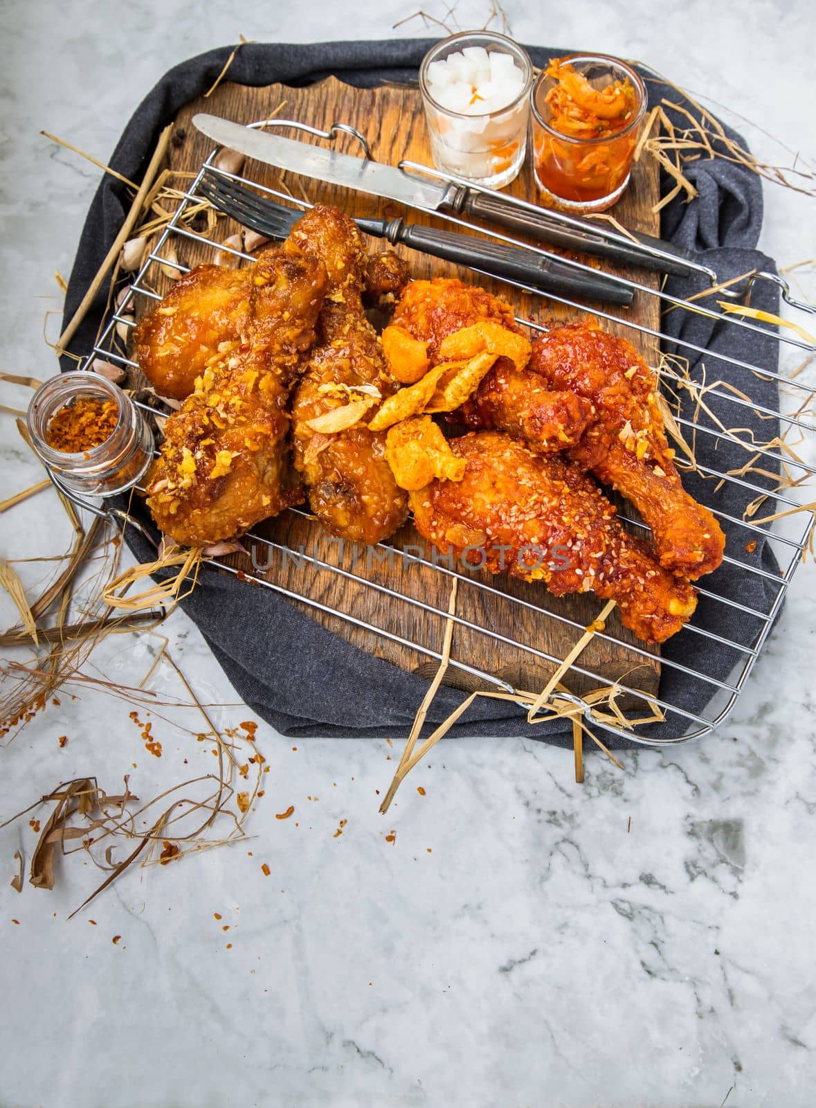 Deep fried chicken drumstick or Crispy fried chicken legs with sesame seeds in garlic sauce in korean style serve with kimchi and pickled radish. Asian food concept, Top view, Copy space, Selective focus.
