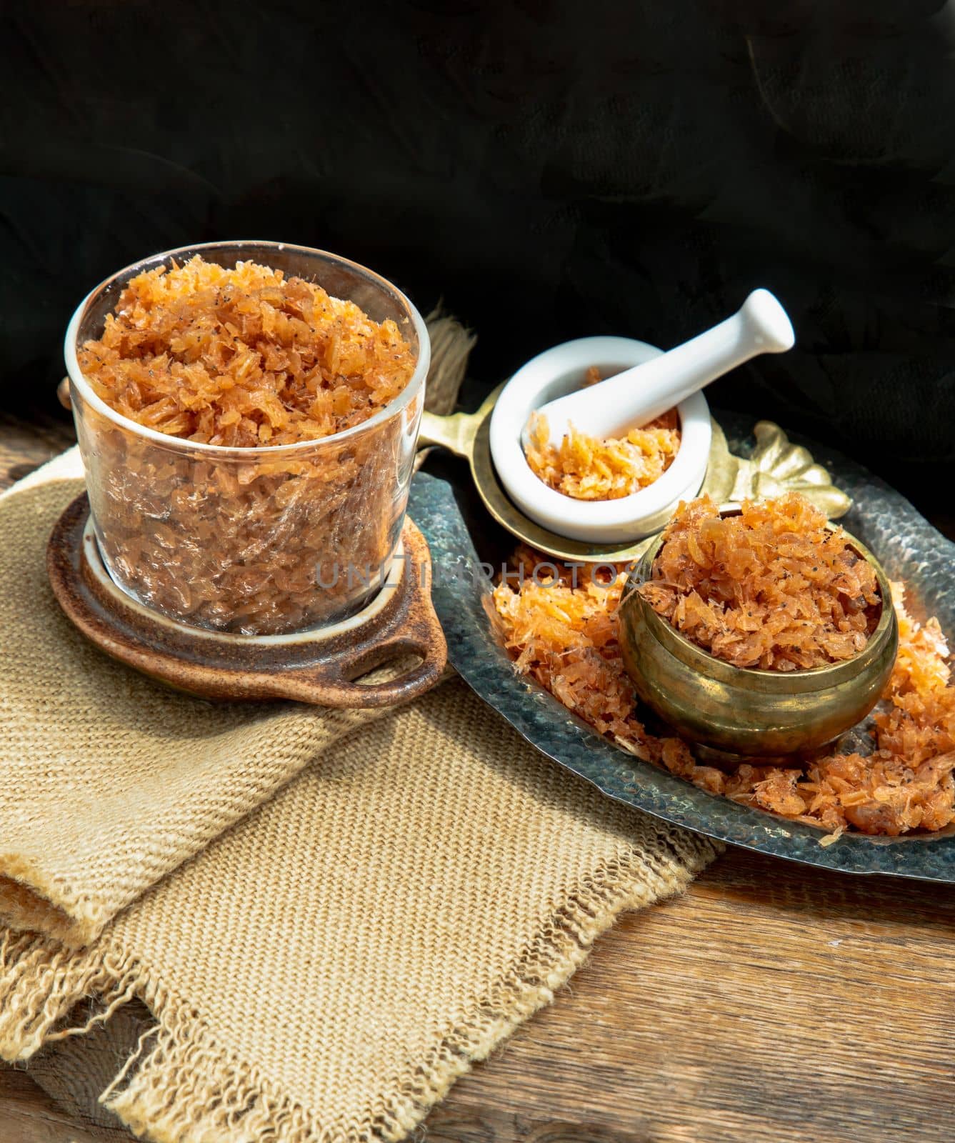 Shrimp paste with Dried shrimps in white Ceramic Bowl on Wooden plank. Copy space, Selective focus.