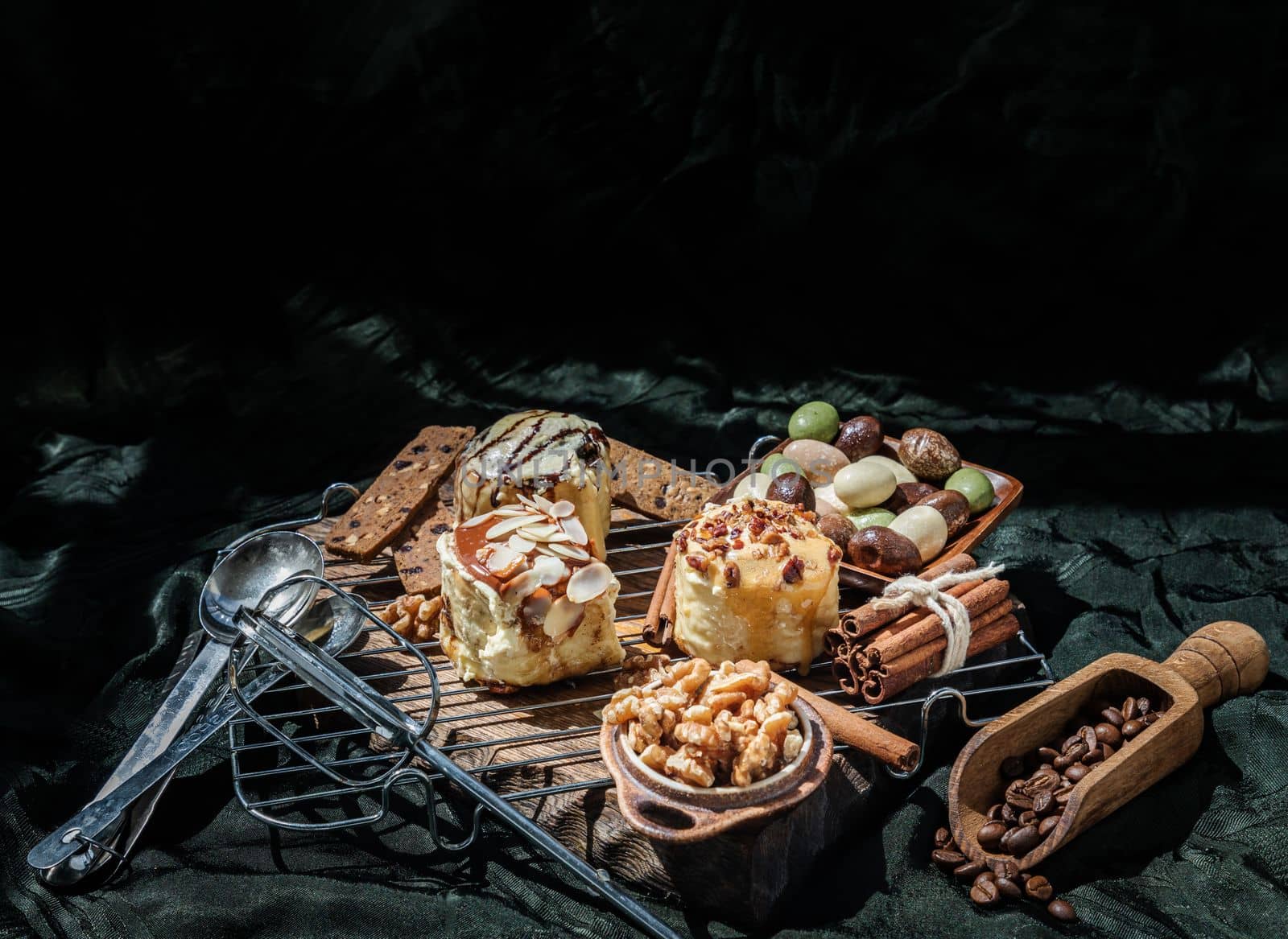 Chocobon (Soft Chocolate Bun) topped with rich cream cheese frosting, Caramel Pecan Cinnamon Roll topped with decadent caramel frosting and pecans and Thai milk tea Almond Minibon with ingredients on dark background. Copy space, Selective focus.