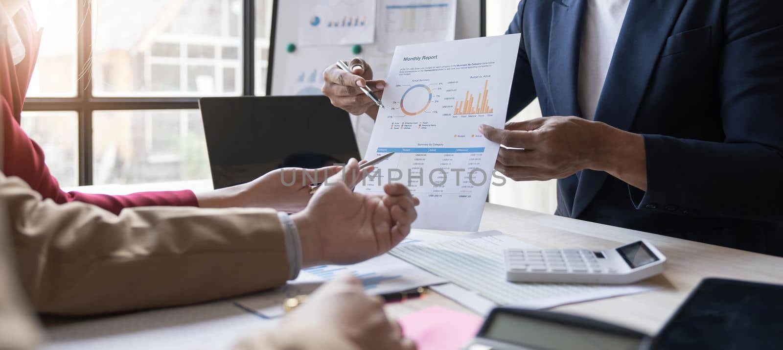 Business People Meeting using laptop computer,calculator,notebook,stock market chart paper for analysis Plans to improve quality next month. Conference Discussion Corporate Concept...