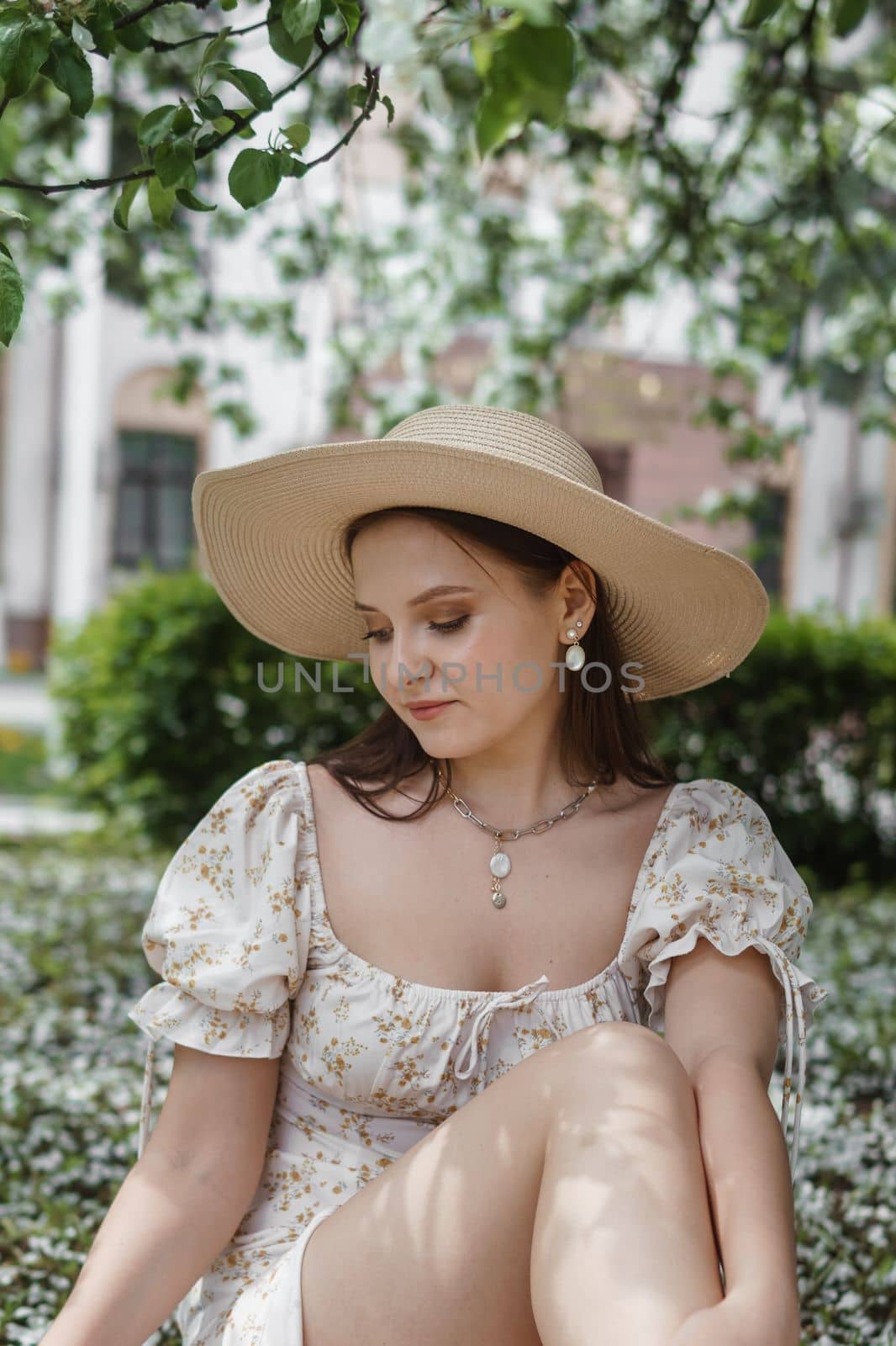 An attractive long-haired woman walks in the spring in the park of blooming apple trees. Spring portrait of a woman