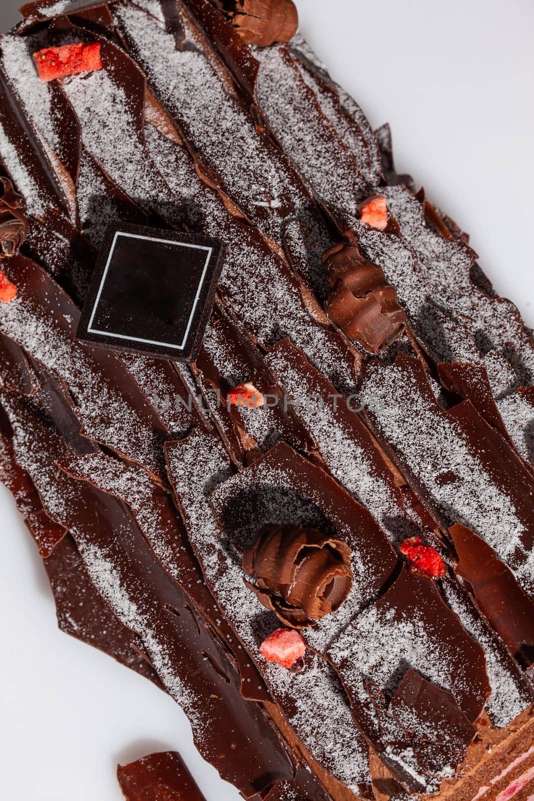 Traditional Yule log with chocolate shavings and candied berries by nazarovsergey