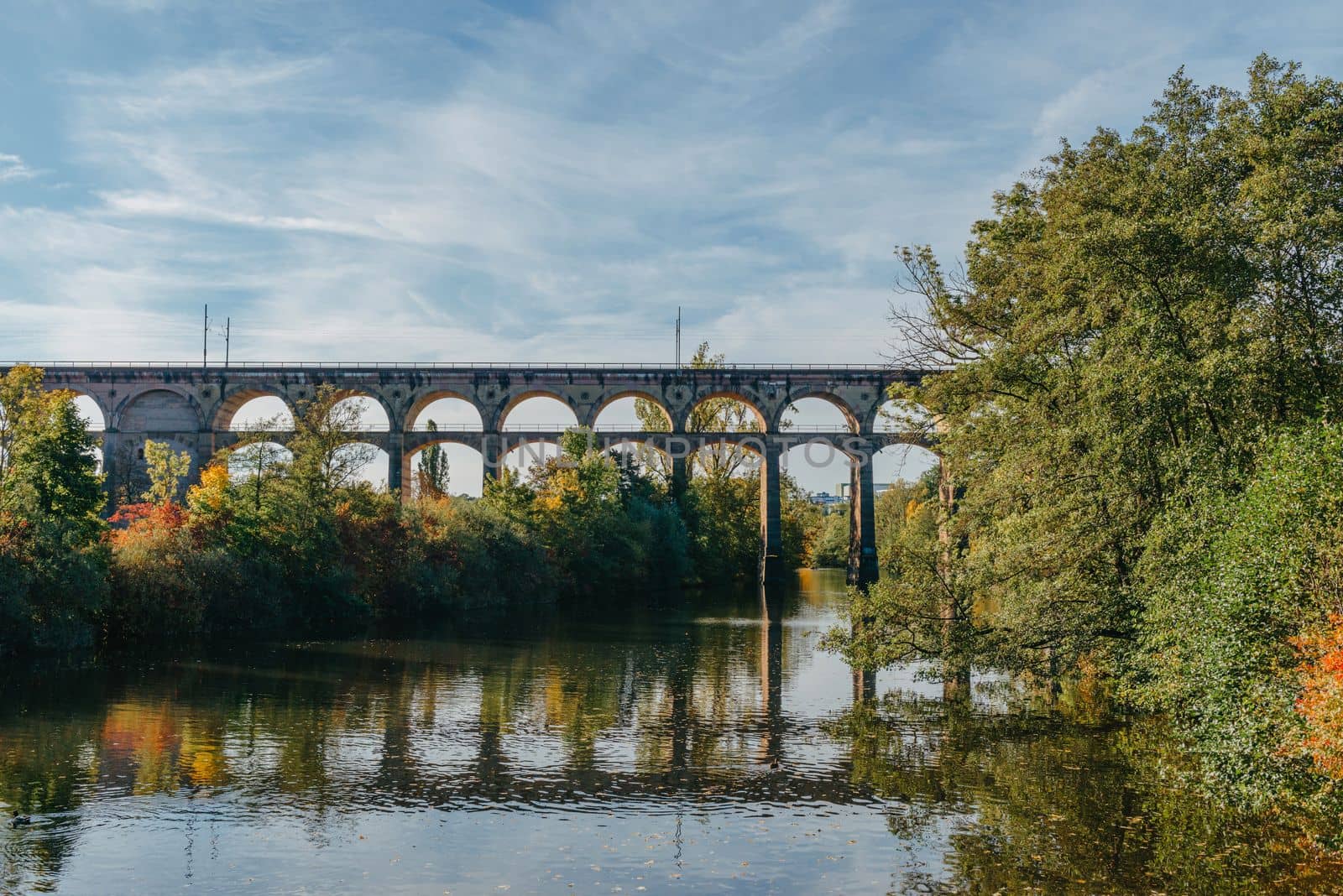 Railway Bridge with river in Bietigheim-Bissingen, Germany. Autumn. Railway viaduct over the Enz River, built in 1853 by Karl von Etzel on a sunny summer day. Bietigheim-Bissingen, Germany. Old viaduct in Bietigheim reflected in the river. Baden-Wurttemberg, Germany. Train passing a train bridge on a cloudy day in Germany