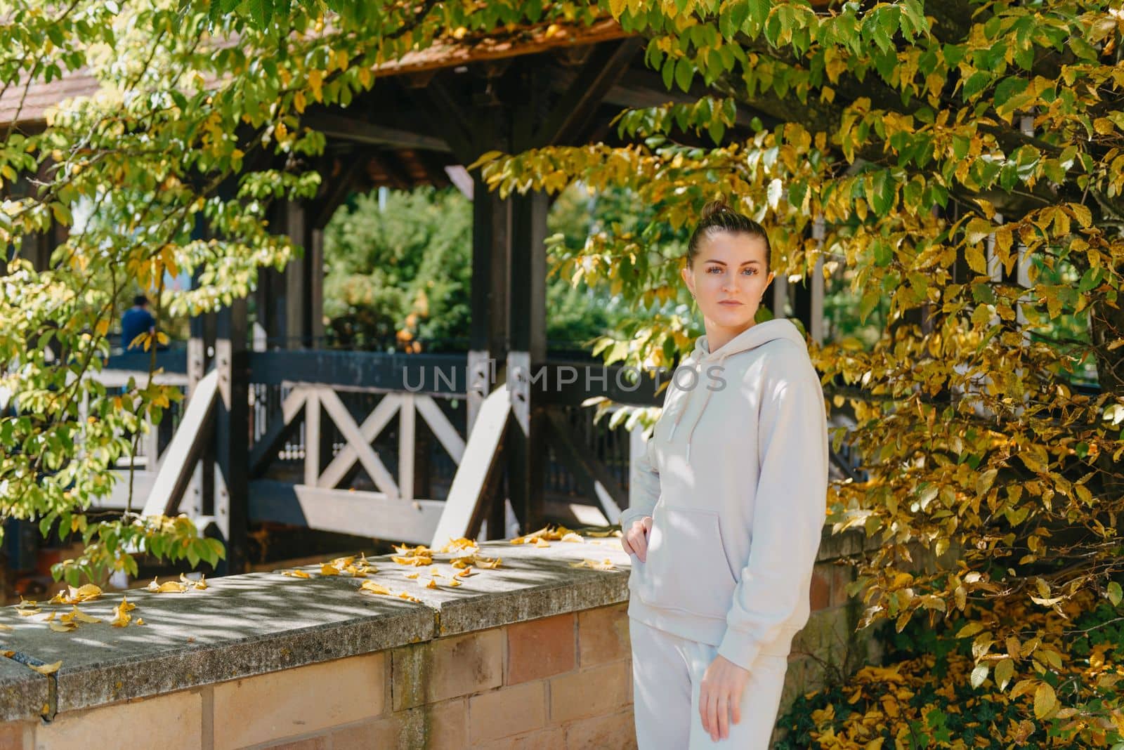 Beautiful elegant woman standing in a park in autumn. autumn yellow leaves. Portrait of joyful woman in park during fall. Happy girl with yellow leaves outdoor. Beauty Romantic Girl Outdoors enjoying nature. Beautiful autumn model with waving glow hair.Sun light on sunset.Warm toned art work. Portrait of romantic female