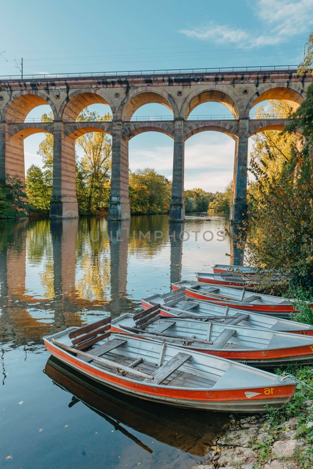 Railway Bridge with river in Bietigheim-Bissingen, Germany. Autumn. Railway viaduct over the Enz River, built in 1853 by Karl von Etzel on a sunny summer day. Bietigheim-Bissingen, Germany. Old viaduct in Bietigheim reflected in the river. Baden-Wurttemberg, Germany. Train passing a train bridge on a cloudy day in Germany