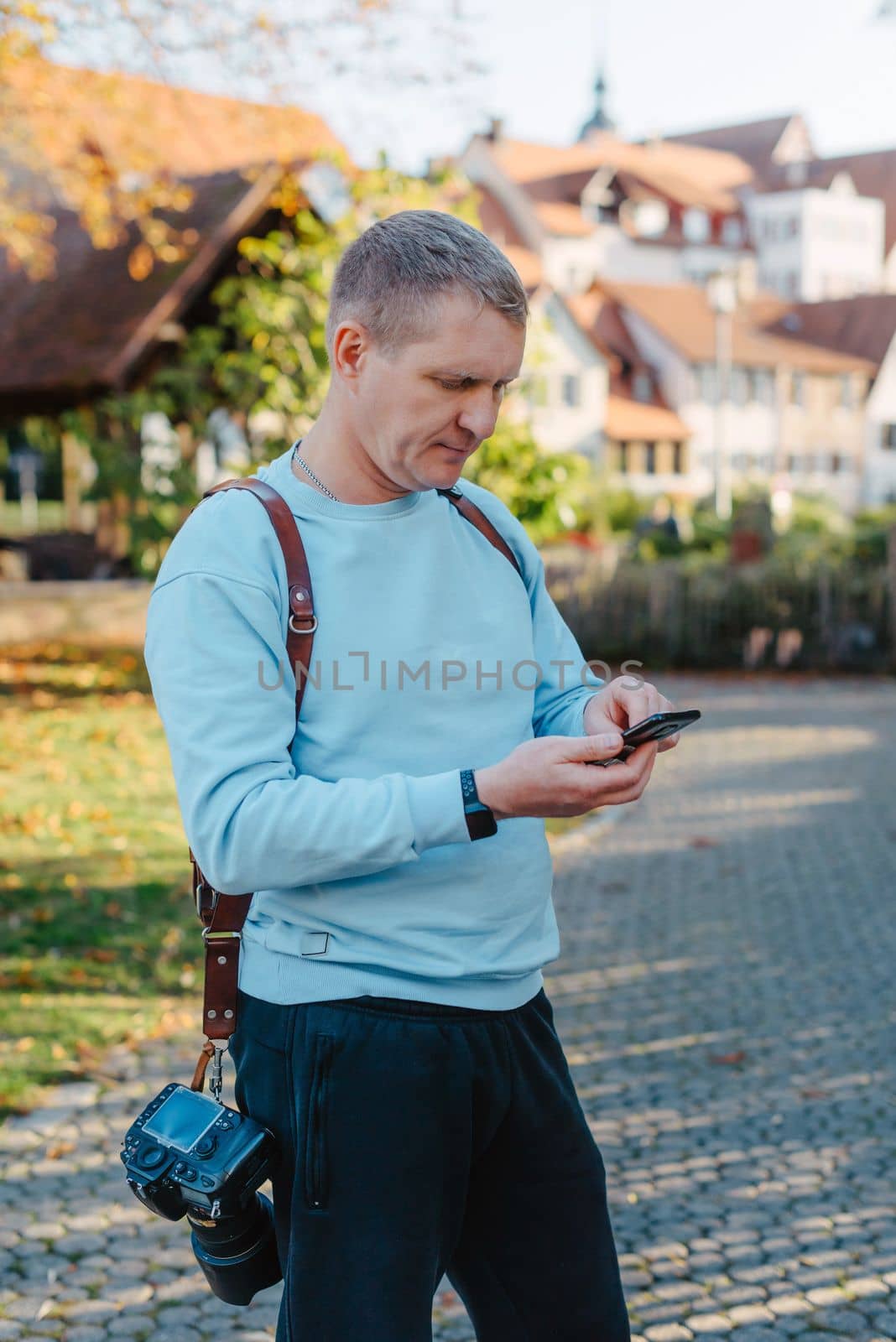 Professional photographer taking picture of beautiful autumn park. man professional photographer sit with camera in autumn park