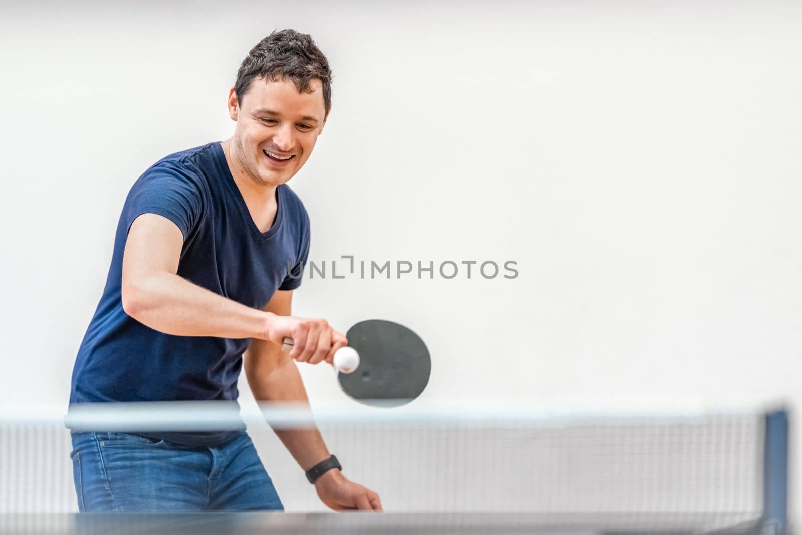 man playing ping pong in gym by Edophoto