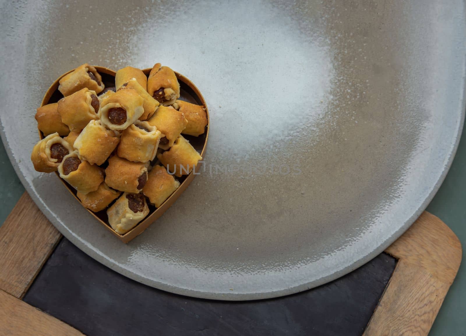 Delicious homemade pineapple rolls tart on heart box. Copy space, Selective focus.