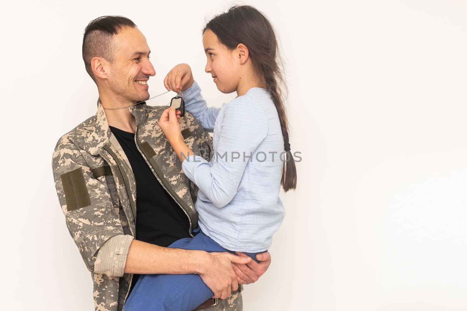 pretty little girl hugging her military father