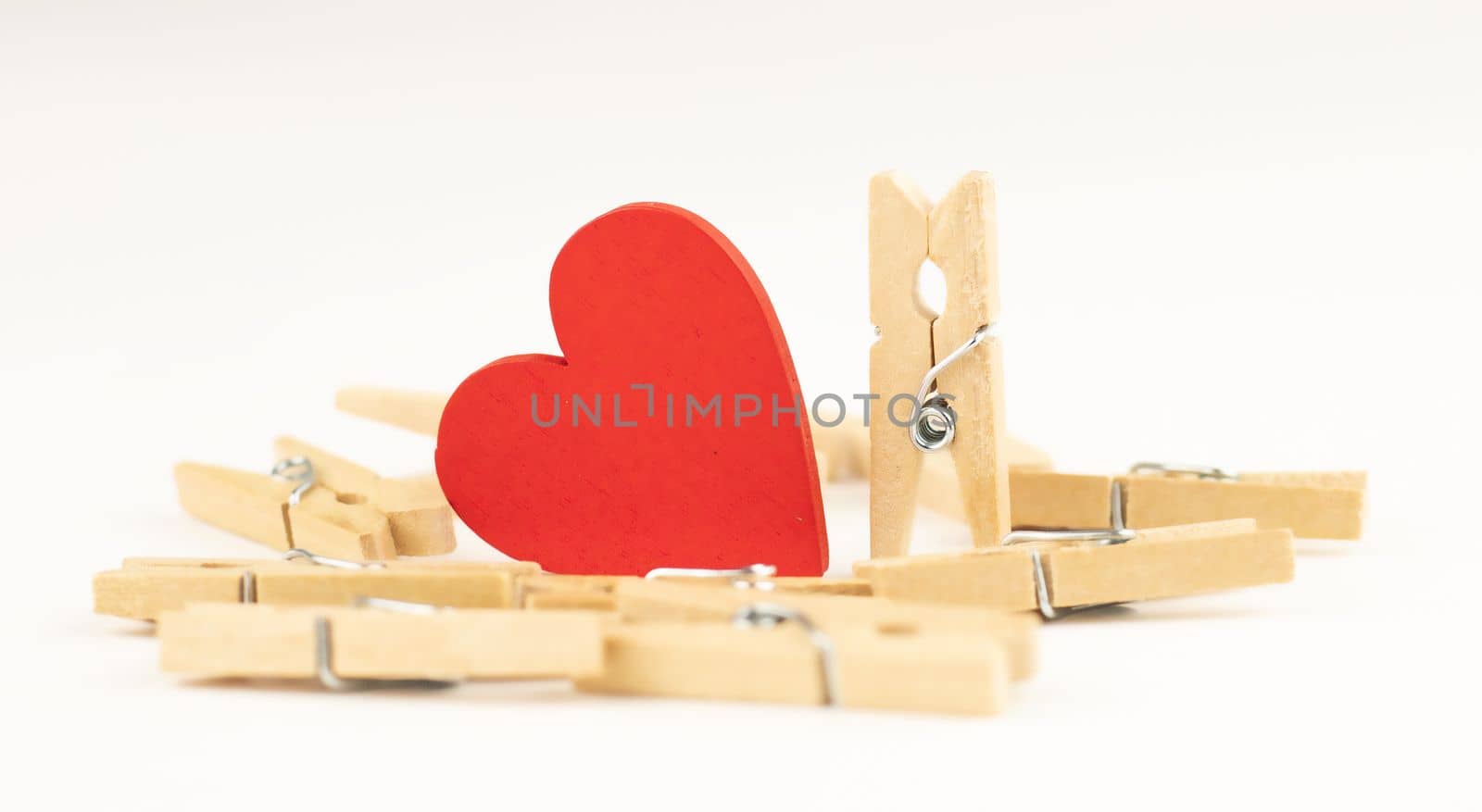 concept composition of love relationships outstanding. clothespins and red wooden heart.