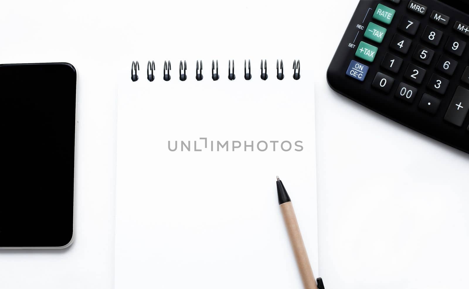 calculator, smartphone, notepad with copy space, pen on the white background top view