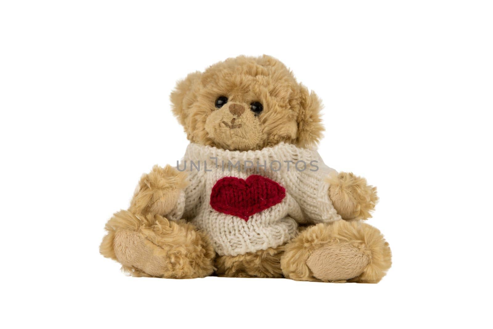 beige teddy bear with heart on its shirt. isolated on white