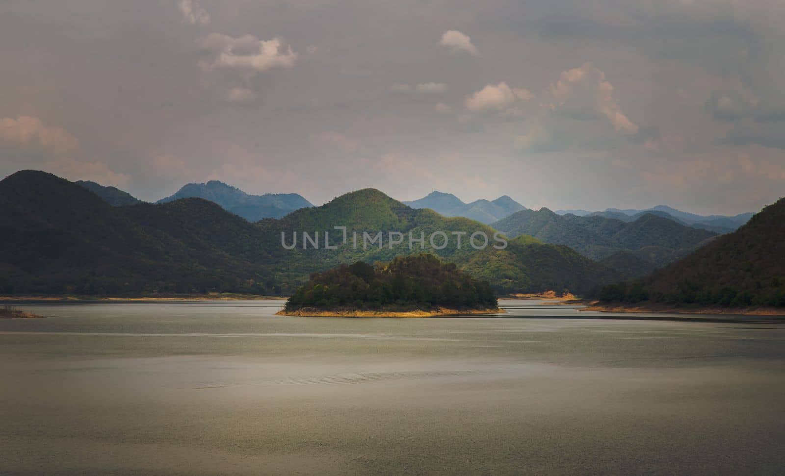 View of lake shore with mountains range in background at sunrise or sunset. Focus and blur.