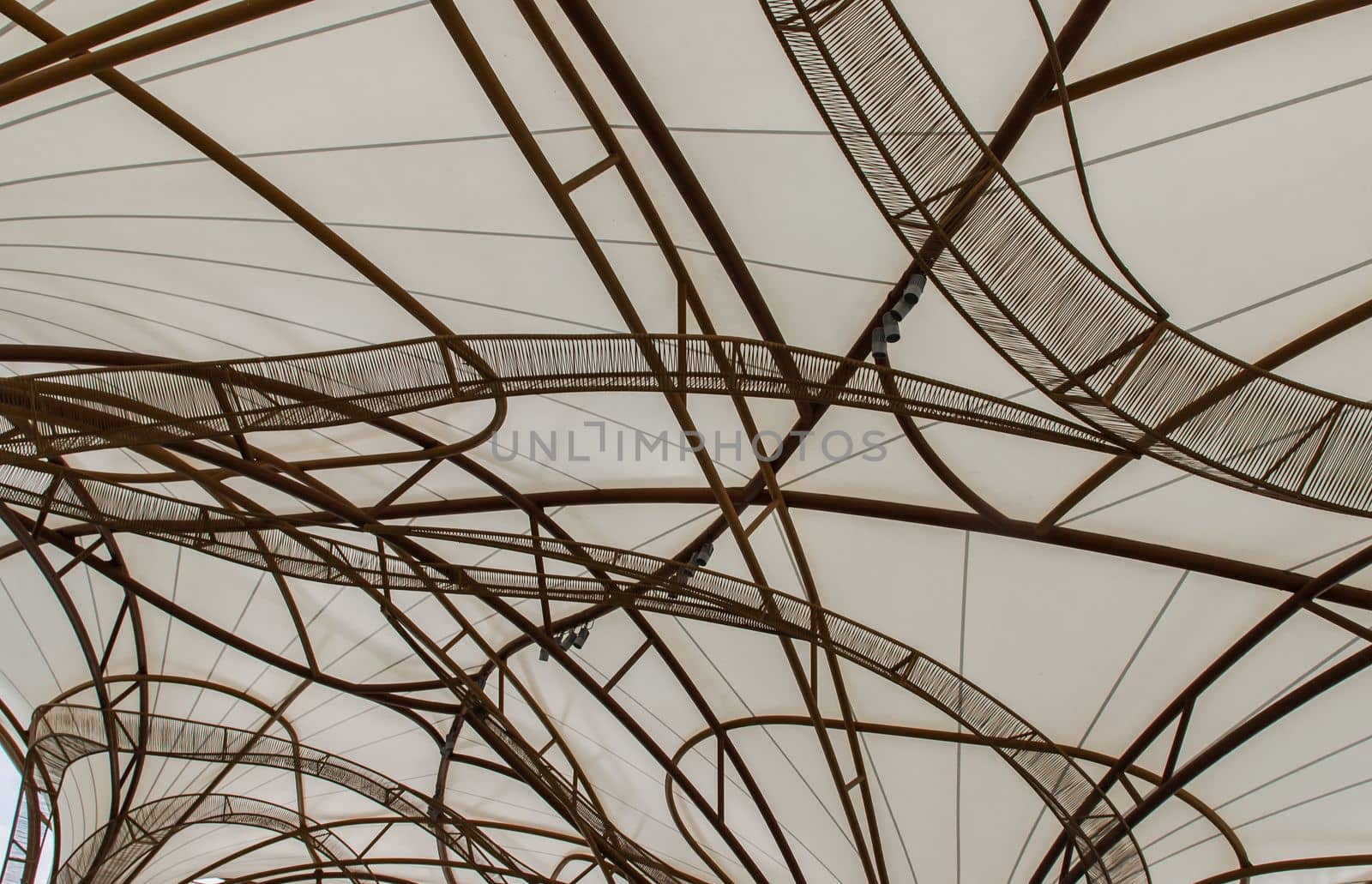 The pattern of steel frame umbrella underside detail with white cloth roof. Selective focus.