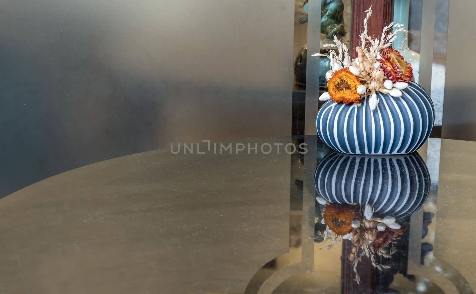 Dried flowers in small handmade ceramic vase  on the reflection on a shiny black table surface. Home decor, Space for text, Selective focus.