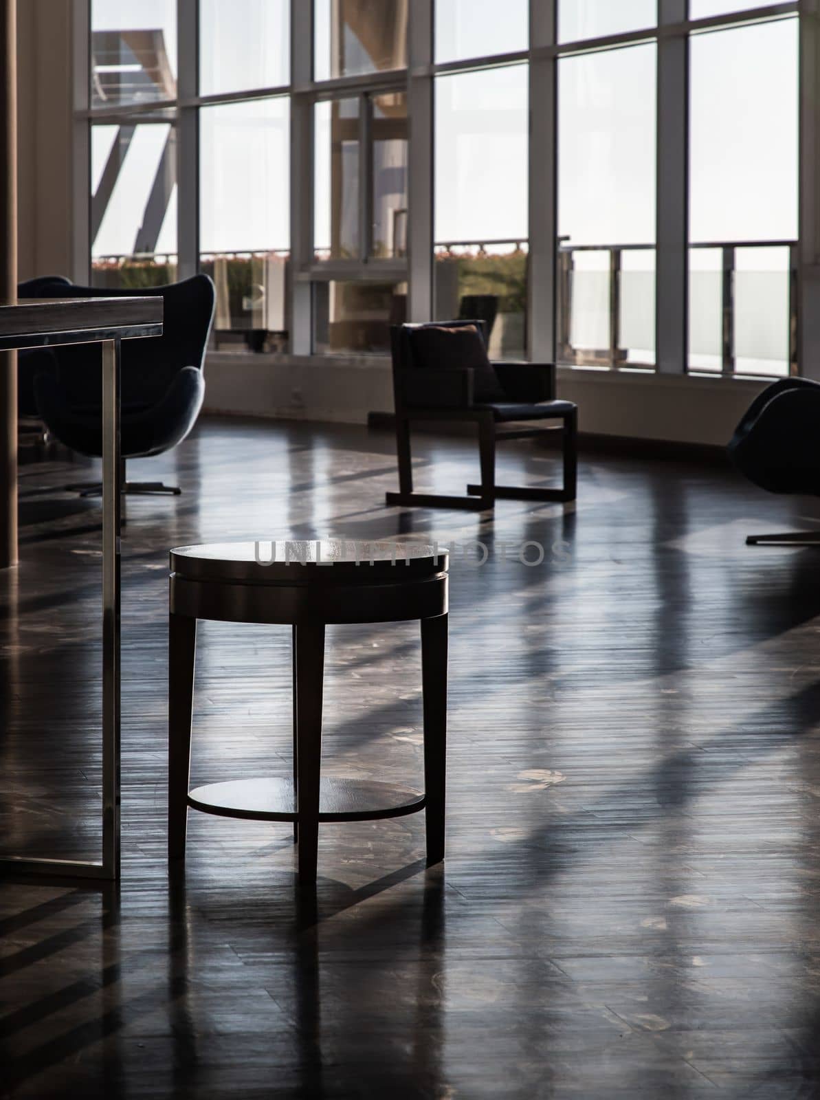 Bangkok, Thailand - Jan 10, 2022 : Wood table small inside in common area with morning sunlight shines through windows at common area. Beautiful light and shadow from the glass windows, Selective focus.
