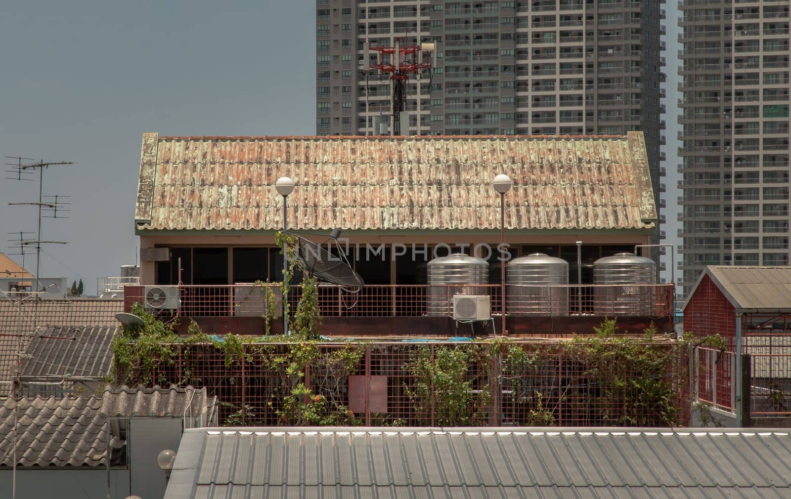 Urban residential old building with 3 stainless steel water tanks for heating water on the balcony. Selective focus.