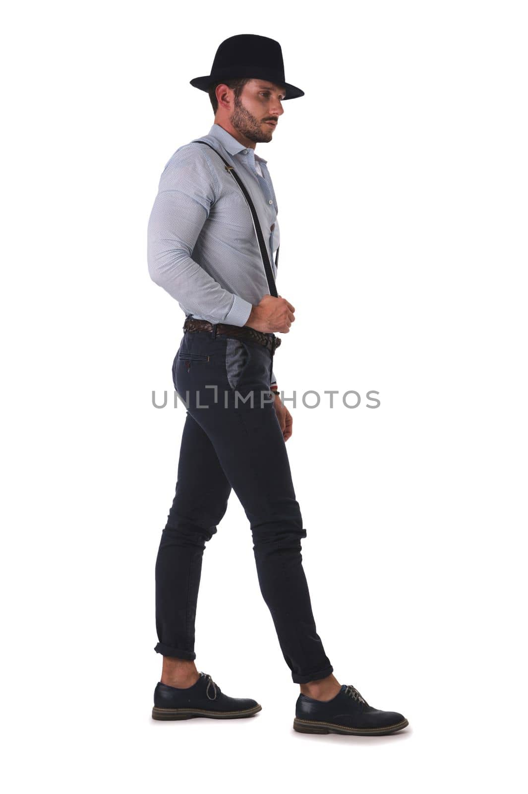 Handsome man in shirt, suspenders, hat and glasses in studio by artofphoto