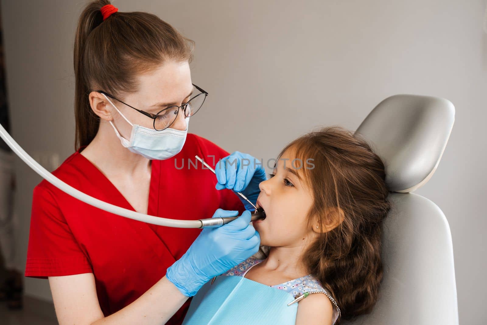 Dental drill. Child dentist drilling teeth of kid girl in dentistry clinic. Dental filling for child patient