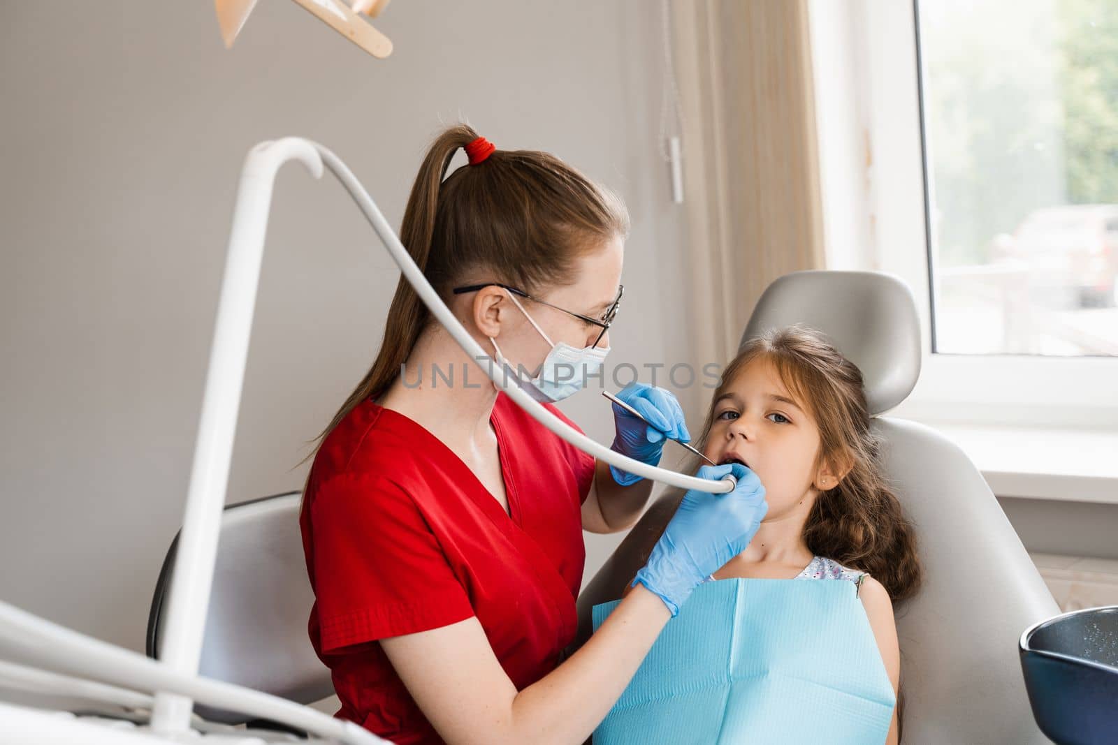 Dental drill. Child dentist drilling teeth of kid girl in dentistry clinic. Dental filling for child patient. by Rabizo