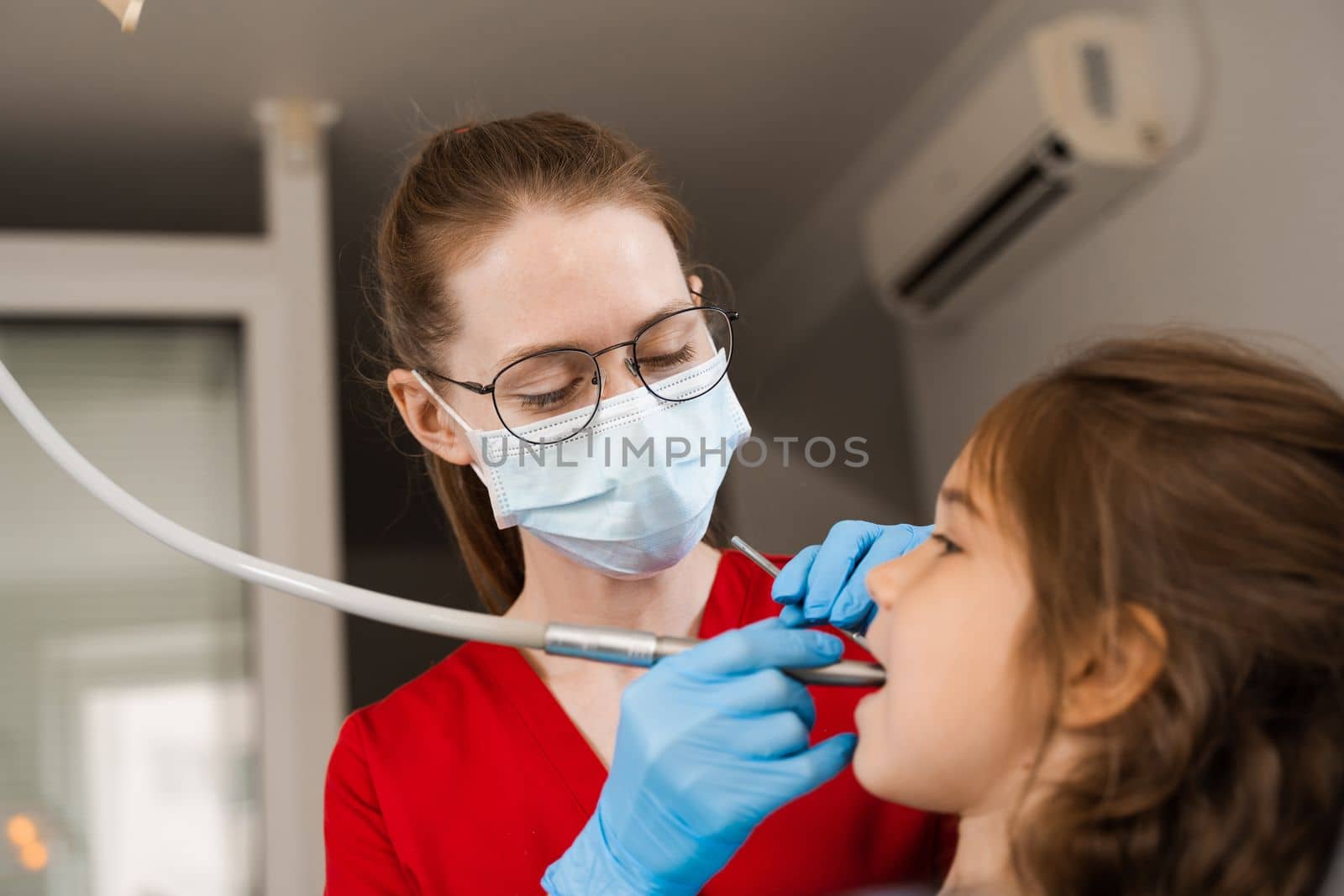 Dental drill. Child dentist drilling teeth of kid girl in dentistry clinic. Dental filling for child patient