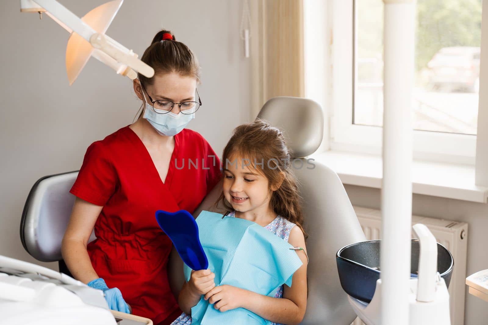 Children dentistry. Dentist and child patient. Consultation with child dentist at dentistry. Teeth treatment. Child looking in the mirror at the dentist. Happy child patient of dentistry. by Rabizo