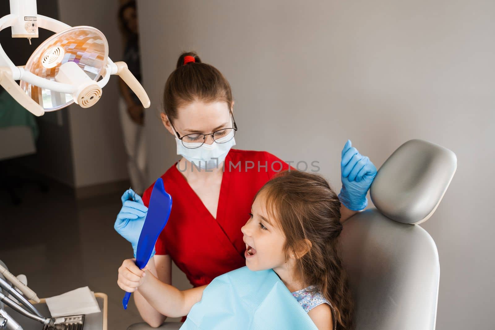 Children dentistry. Dentist and child patient. Consultation with child dentist at dentistry. Teeth treatment. Child looking in the mirror at the dentist. Happy child patient of dentistry. by Rabizo