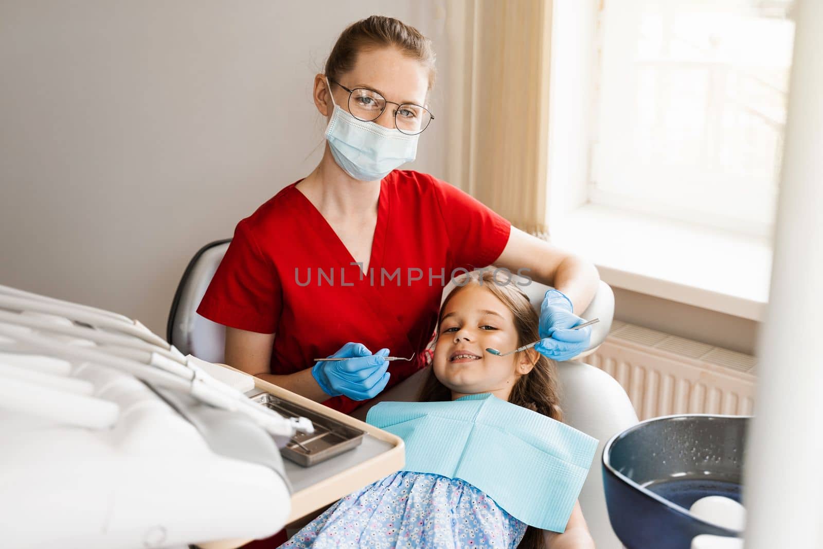 Cheerful child girl smiling at dentists consultation in dentistry. Dental diseases. Consultation with pediatric dentist for treatment of toothache in child. by Rabizo