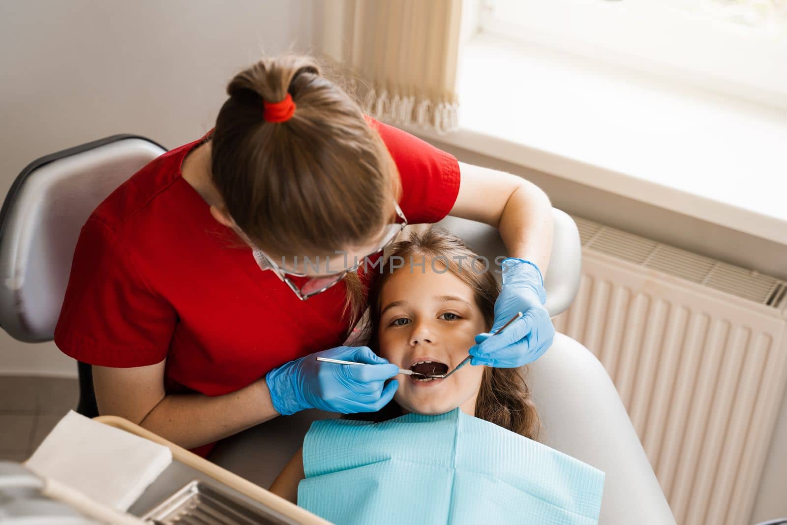 Consultation with pediatric dentist in dentistry. Pediatric dentist examines teeth of child girl for treatment of toothache. Pain in teeth in children. by Rabizo