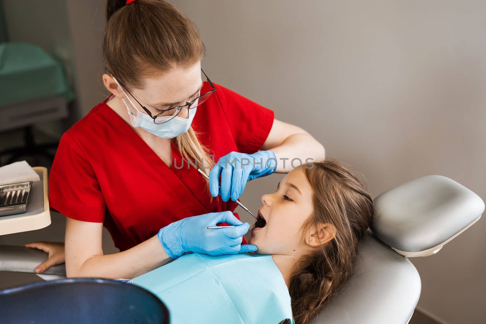 Pediatric dentist and cheerful girl child smiling in dentistry. Child smiles at the consultation with dentist. Creative advertising for dentistry