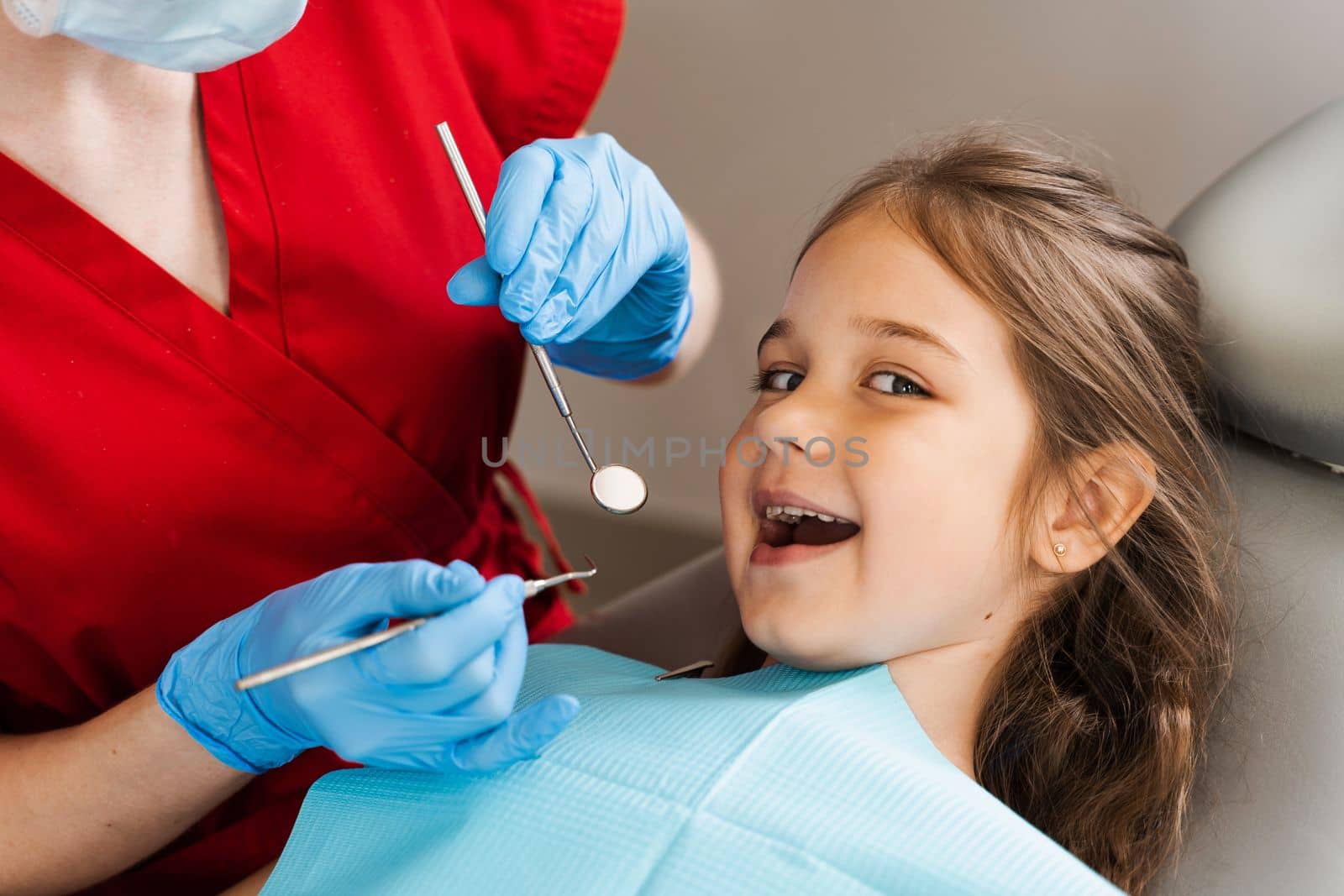 Cheerful child girl smiling at dentists consultation in dentistry. Dental diseases. Consultation with pediatric dentist for treatment of toothache in child