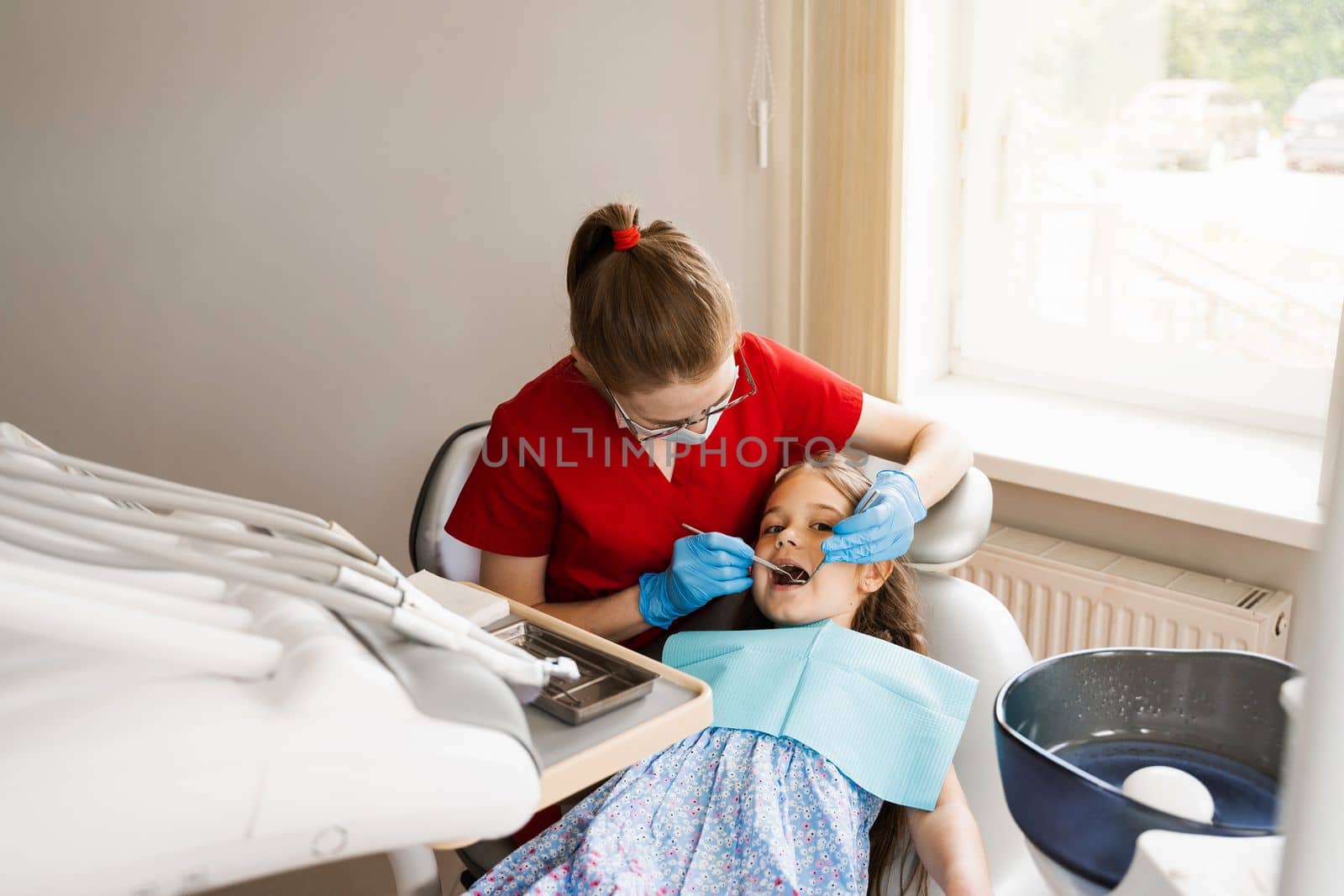 Cheerful child girl smiling at dentists consultation in dentistry. Dental diseases. Consultation with pediatric dentist for treatment of toothache in child. by Rabizo